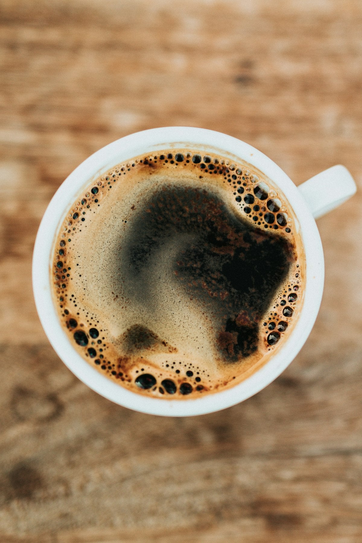 White cup of black coffee with fresh crema, the difference freshly roasted beans make