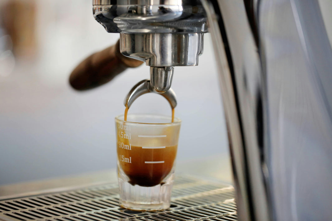 Espresso pulling from a portafilter into a glass measuring cup — Agross Cebu
